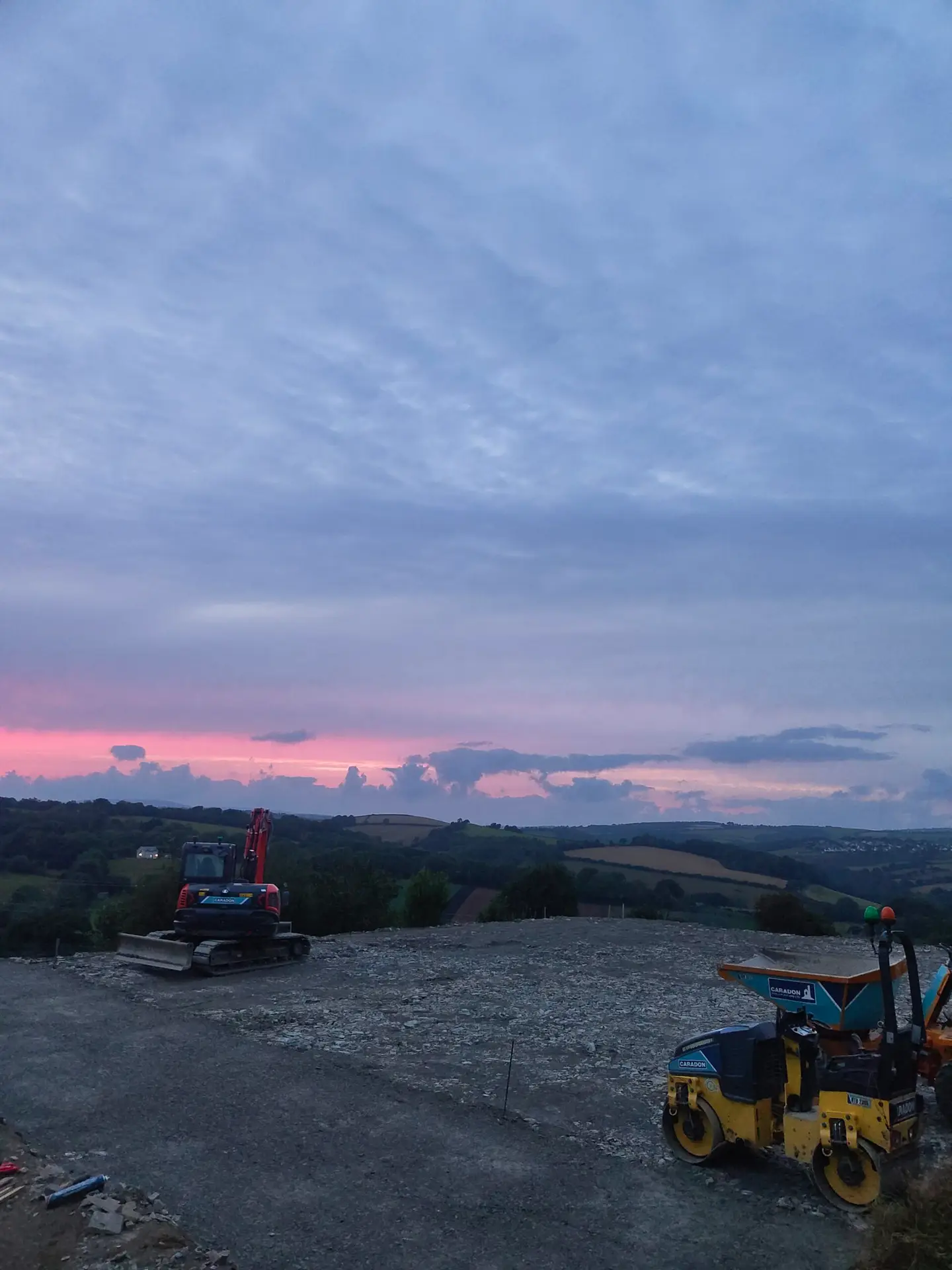shows one of alwoods landscaping ltd jobs with an excavator and dumper and roller sat in beautiful scenery